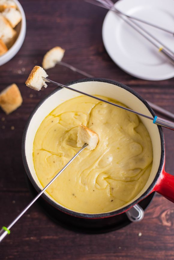 a pan filled with yellow sauce and bread sticks