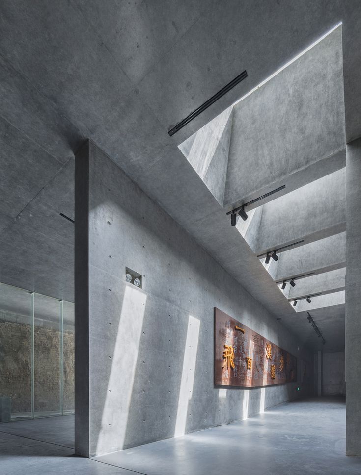 an empty room with concrete walls and windows