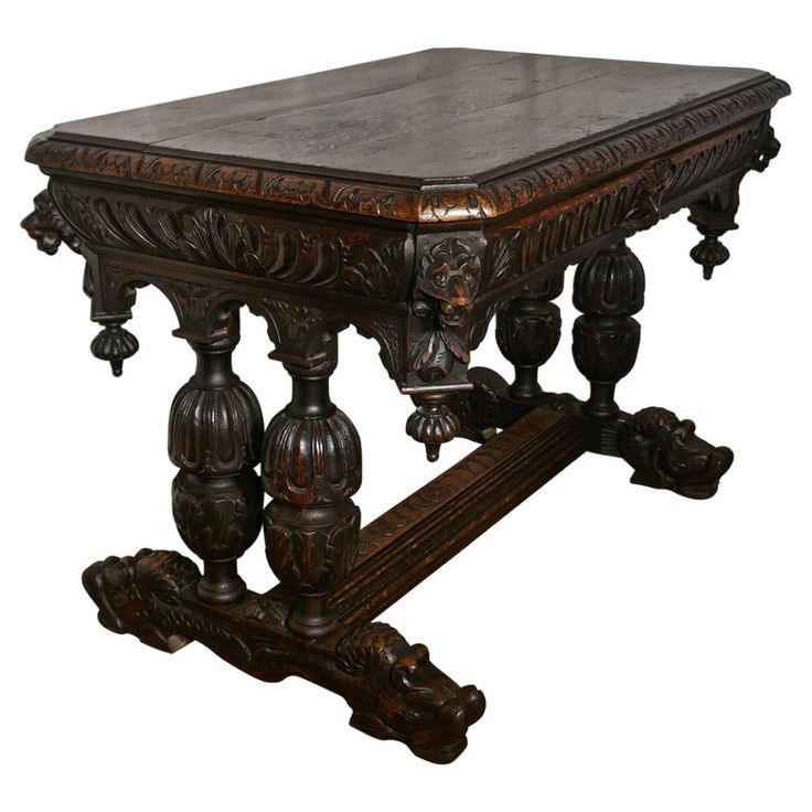 an ornate wooden table with carved details on the top and bottom, against a white background