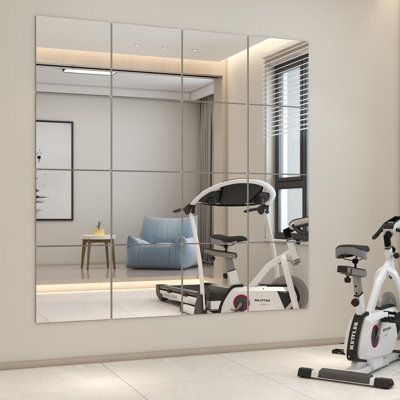 there is a gym with exercise equipment in the room and a mirror on the wall