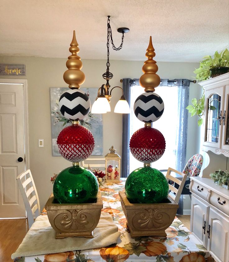 two green and red vases sitting on top of a wooden table in a kitchen