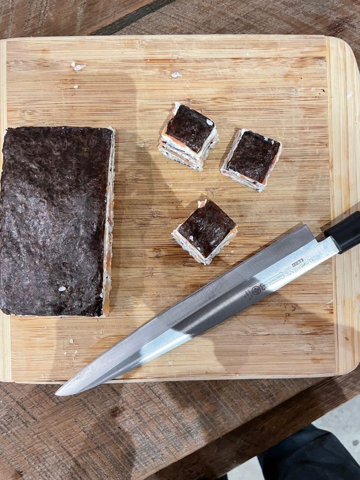 a cutting board topped with brownies and a knife