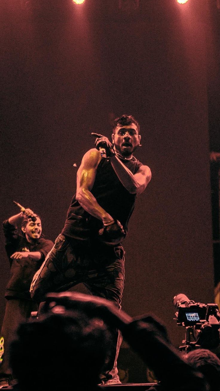 a man standing on top of a stage holding a microphone