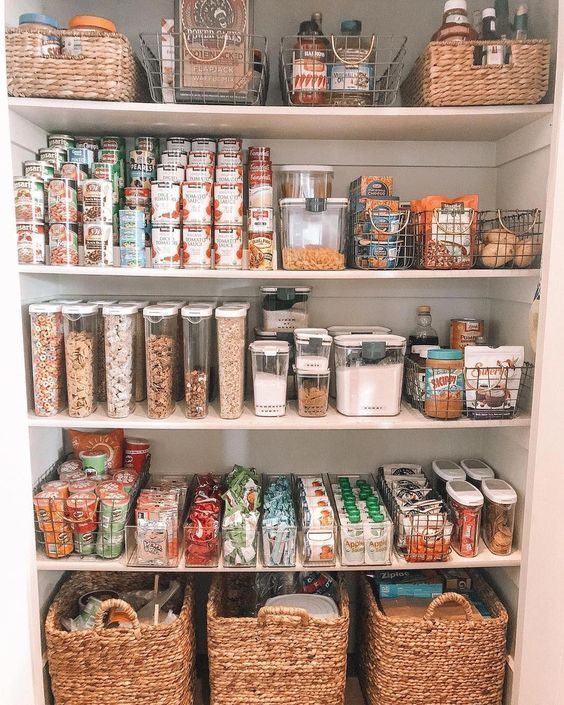 a pantry filled with lots of food and storage baskets on top of white shelving