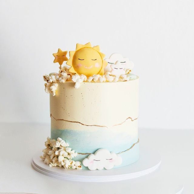 there is a cake that has been decorated with stars and clouds on the top layer