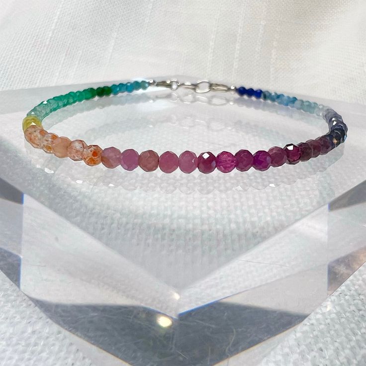 "This colorful, dainty beaded bracelet is made with tiny 2mm faceted round gemstone beads in a rainbow of gorgeous colors! The gemstones are arranged in an ombre shaded pattern, and include a variety of semi-precious stones and crystals carefully strung on flexible aluminum wire. Perfect for celebrating or showing your support for Pride, or just for those who love rainbows and colorful jewelry! This piece can also be made as an anklet or necklace, just select the length you prefer or message us Pride Jewelry, Pride Jewellery, Bracelet Rainbow, Colorful Bracelet, Rainbow Gemstones, Bead Choker, Rainbow Bracelet, Rainbow Beads, Colorful Jewelry