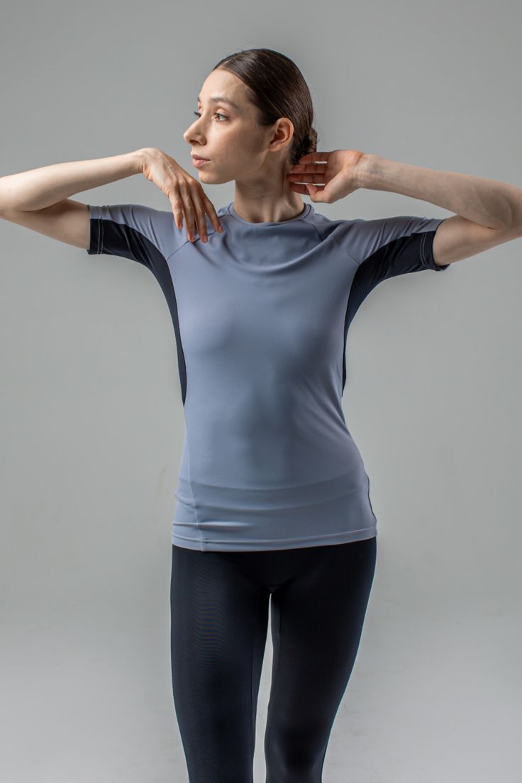 Design. Grey women's rash guard t-shirt with an anatomical fit. Tight, secure fit on the body. Seam placement provides maximum comfort for wide amplitude movements of arms and torso. Grey dance stretch T-shirt for women. Material. Italian biflex - elastic, highly durable, dries quickly, doesn't deform. NB Sweat is less visible on more vibrant and darker colours. Design and technology consider the intensity of dancing and sport activities. Fitted Athleisure T-shirt For Training, Micro-elastic Gym Tops With Go-dry, Moisture-wicking Micro-elastic Tops For Gym, Breathable Micro-elastic Workout Tops, Breathable Micro-elastic Yoga Top, Micro-elastic Go-dry Top For Workout, Micro-elastic Sportswear Tops For Yoga, Functional Micro-elastic Tops For Workout, Micro-elastic Functional Workout Tops