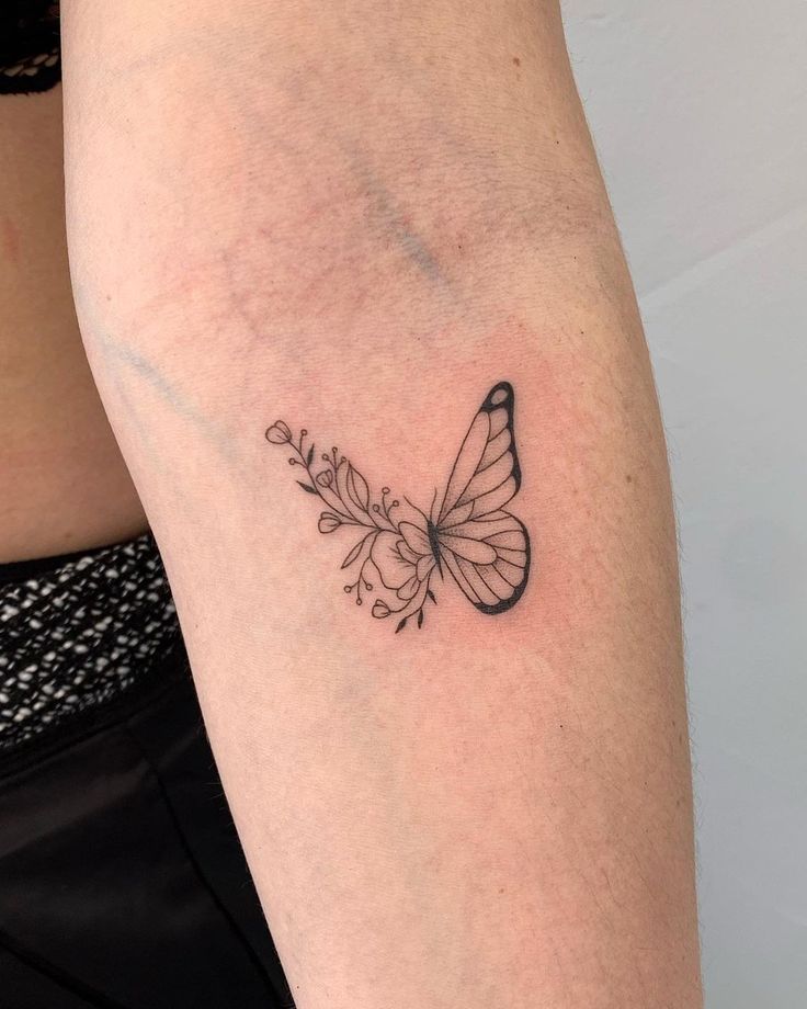 a woman's arm with a butterfly tattoo on the left side of her body