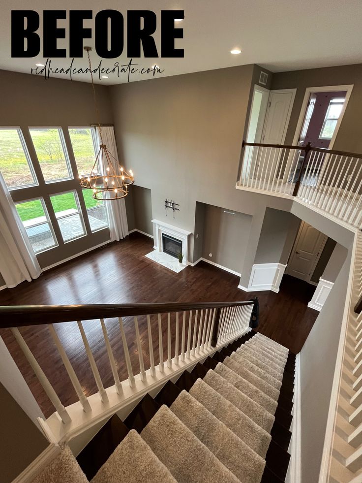 an overhead view of a living room with stairs leading up to the second floor and windows