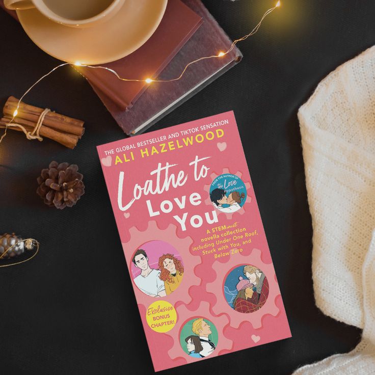 the book loathe to love you by ali hazlelwood sits on a table next to a cup of coffee