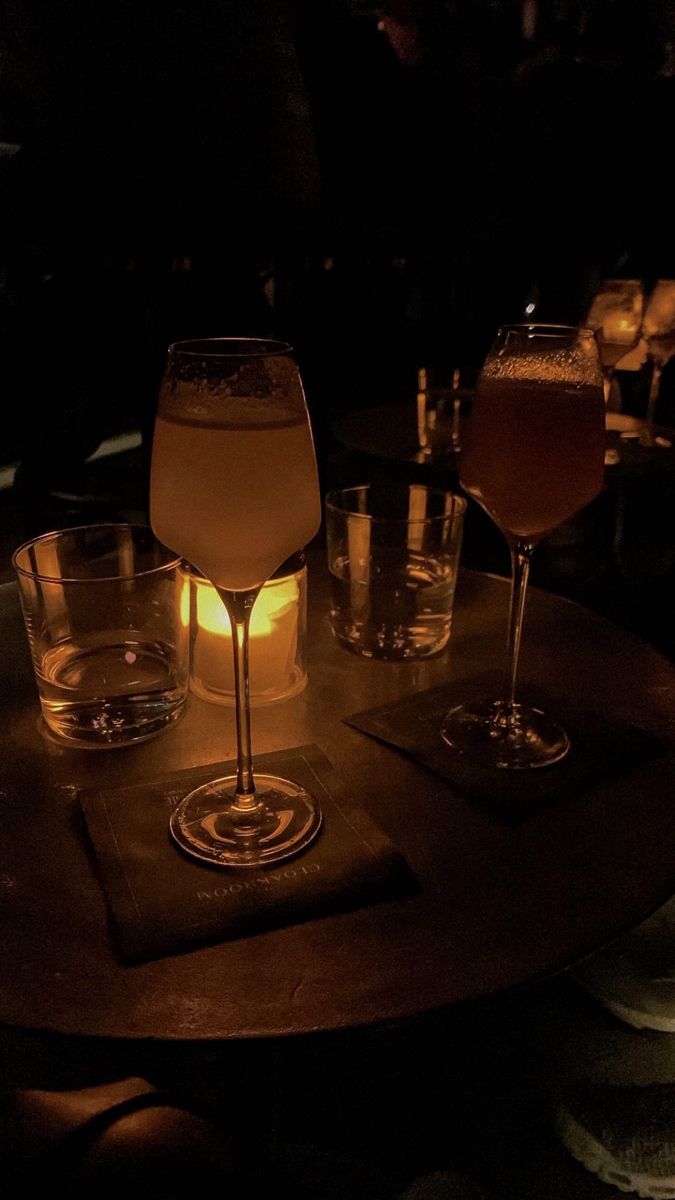 several glasses are sitting on a table in the dark