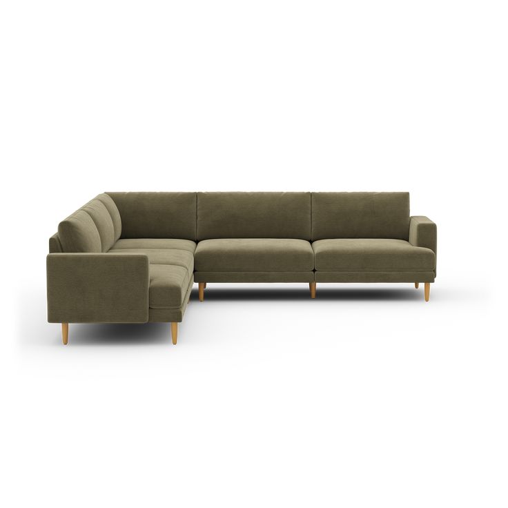 a large sectional couch sitting on top of a white floor next to a wooden leg chair