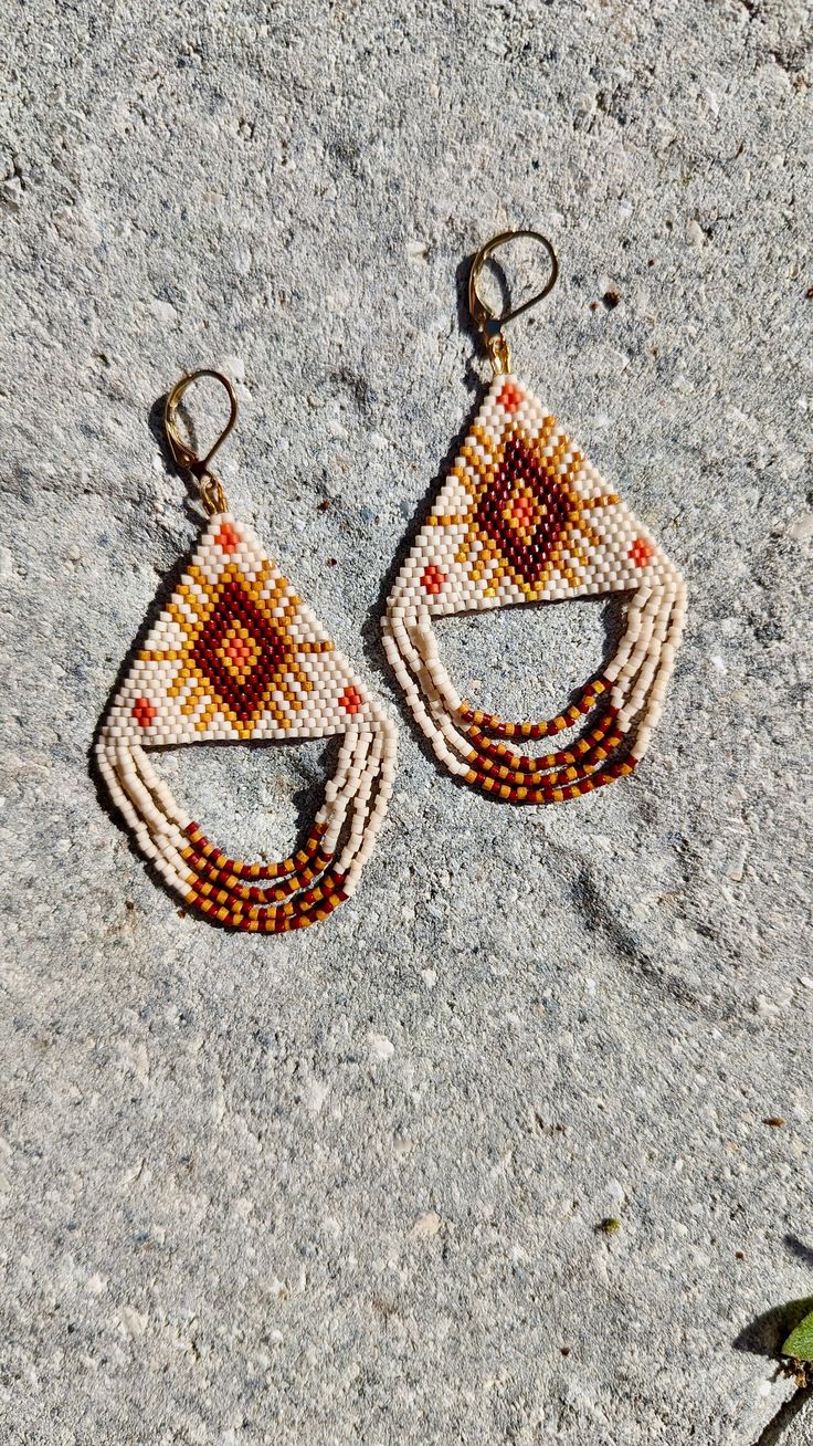 Hand beaded, patterned earrings in a triangle with dangle fringe.