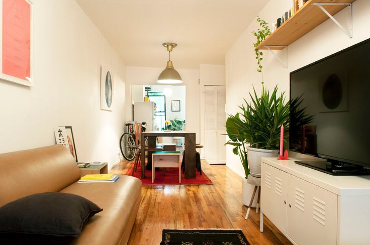 a living room filled with furniture and a flat screen tv on top of a wooden floor