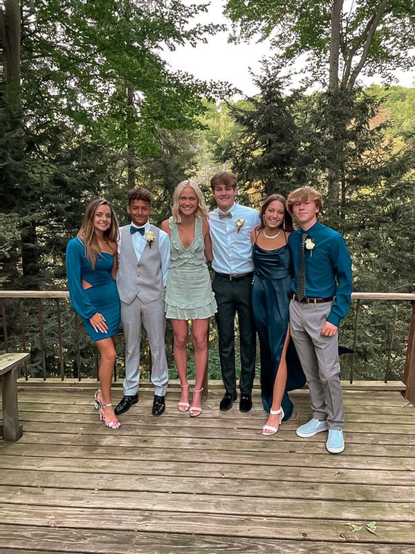 a group of young people standing on top of a wooden deck next to each other