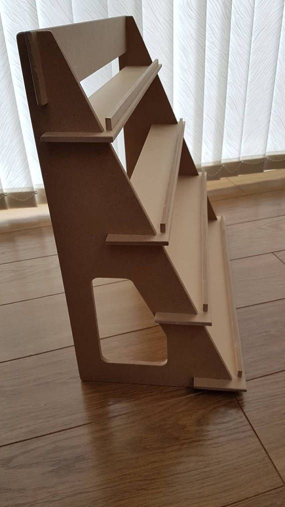 a sculpture made out of cardboard sitting on top of a wooden floor next to a window