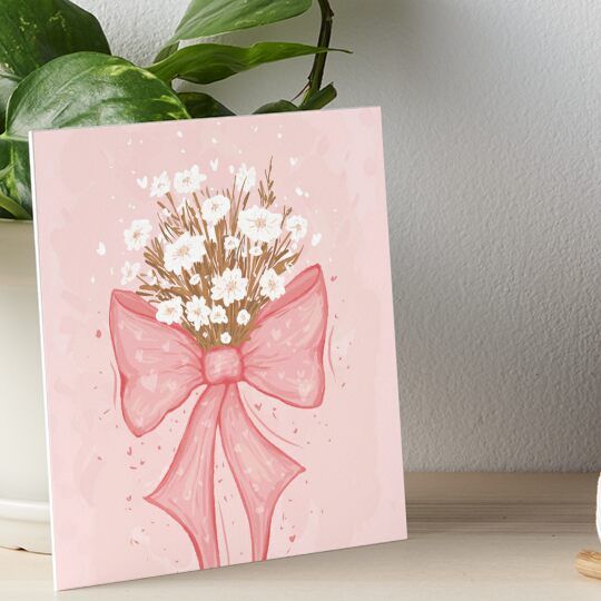 a pink card with a bow and flowers on it art board print by artist unknown