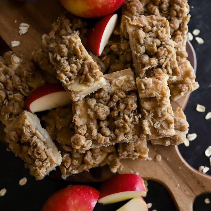 apples and granola bars on a wooden cutting board