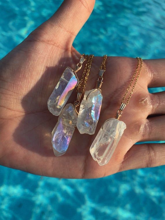 This wire wrapped Angel Aura Quartz healing crystal necklace is a minimalist style perfect in your healing, meditative or sacred space to create a soothing, serene, and spiritual vibe. This raw polished quartz pendant is wrapped and hung on a delicate gold chain measuring 18 inches with an additional adjustable 2" extender. Makes a great gift for friends or family!Due to the unique nature of crystals, each necklace will slightly differ by 1-2 cm in length or width. Each pendant is approximate 1" Minimalist Gemstone Crystal Necklace For Healing, Minimalist Mineral Crystal Pendant Necklaces, Minimalist Crystal Pendant Necklace For Meditation, Minimalist Pendant Crystal Necklace For Meditation, Quartz Crystal Necklace With Raw Stone For Healing, Minimalist Mineral Crystal Pendant Necklace, Minimalist Handmade Crystal Healing Necklace, Magical Wire Wrapped Crystal Necklaces As A Gift, Magical Wire Wrapped Crystal Necklaces For Gifts