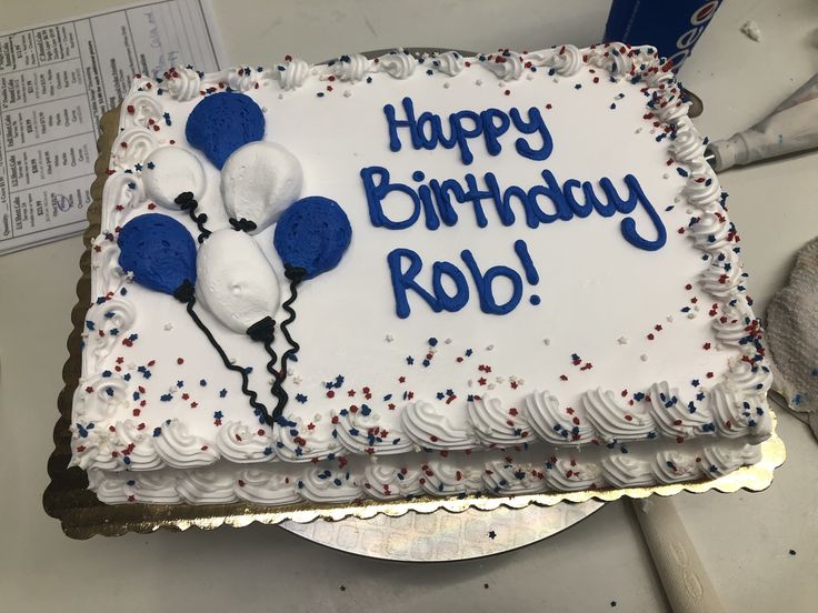 a birthday cake with white frosting and blue balloons on it that says happy birthday rob