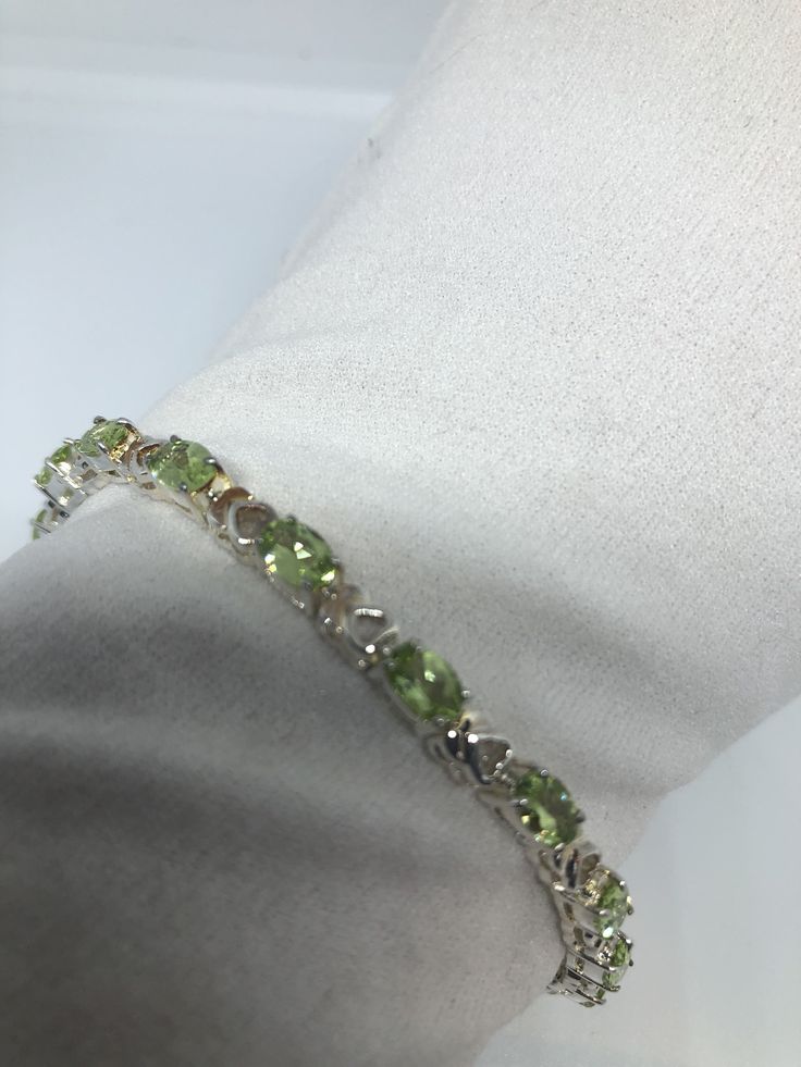 This Peridot bracelet is very lively and bright. The stones are deep colors and well matched. The sterling silver is plated with rhodium to protect the bracelet from tarnish and give the appearance of white gold. 7.5 inches My jeweler can shorten it All jewelry is shipped in a nice gift box. Check out our over a THOUSAND great reviews Engraving is $4 per letter and is not always perfect depending on the piece. It can take a few days if the jeweler is busy. This is payable to Paypal Judithsltd@gm Sterling Silver Bracelet With Green Gemstone, Green Round Sterling Silver Bracelet, Elegant Green Sterling Silver Jubilee Bracelet, Green Bangle Tennis Bracelet For Anniversary, Lime Green Bracelet Jewelry For Gift, Anniversary Green Sterling Silver Bracelets, Green Jubilee Bracelet For Anniversary, Green Sterling Silver Bangle Bracelet, Green Sterling Silver Round Bracelet