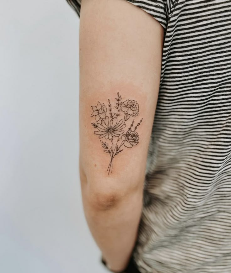 a woman with a flower tattoo on her arm