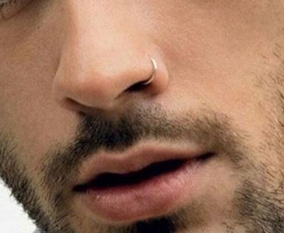 a close up of a man with a nose piercing