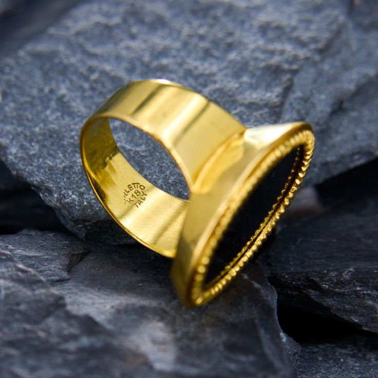 a gold ring sitting on top of a rock