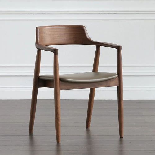 a wooden chair sitting on top of a hard wood floor next to a white wall