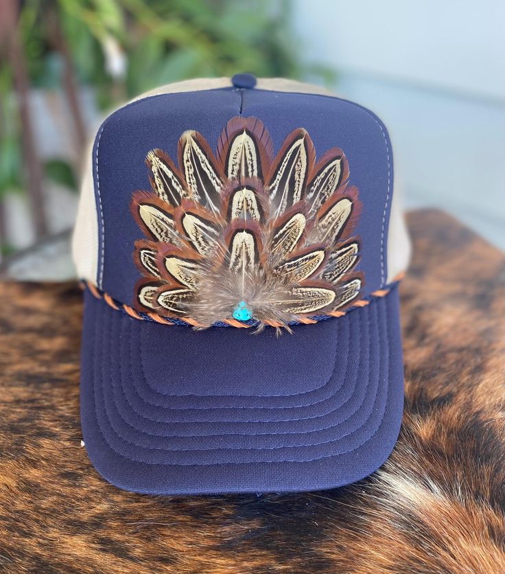 Beautiful pheasant feathered trucker hat in  Navy. Handmade embellishment on a 5 Panel, foam front Trucker Hat. Country Concerts Western Attire Rodeos Girls night out Boho cowgirl indie Stagecoach Outfit summer hat Beach hat Western Style Adjustable Trucker Hat For Ranch, Adjustable Western Trucker Hat For Ranch, Adjustable Country Hat With Feather Trim, Adjustable Country Hats With Feather Trim, Adjustable Country Style Hat With Feather Trim, Western Style Trucker Hat For Festivals, Bohemian Rodeo Hat With Feather Trim, Western Style Adjustable Trucker Hat, Bohemian Hats With Feather Trim For Rodeo