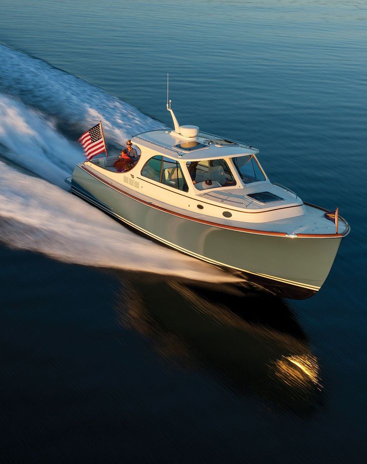 a small motor boat speeding across the water with an american flag on it's side