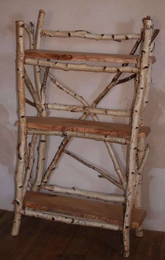 a wooden shelf made out of branches in a room with wood flooring and walls