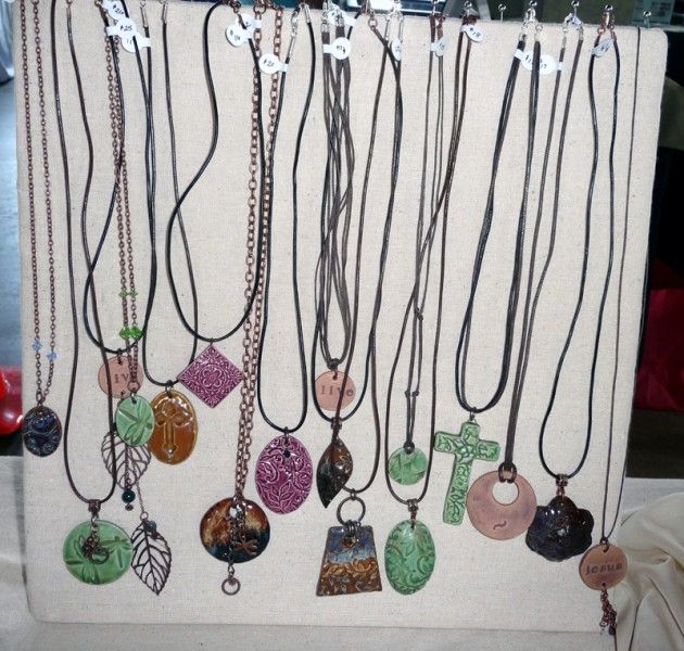 there are many different necklaces hanging on the display rack in front of each other