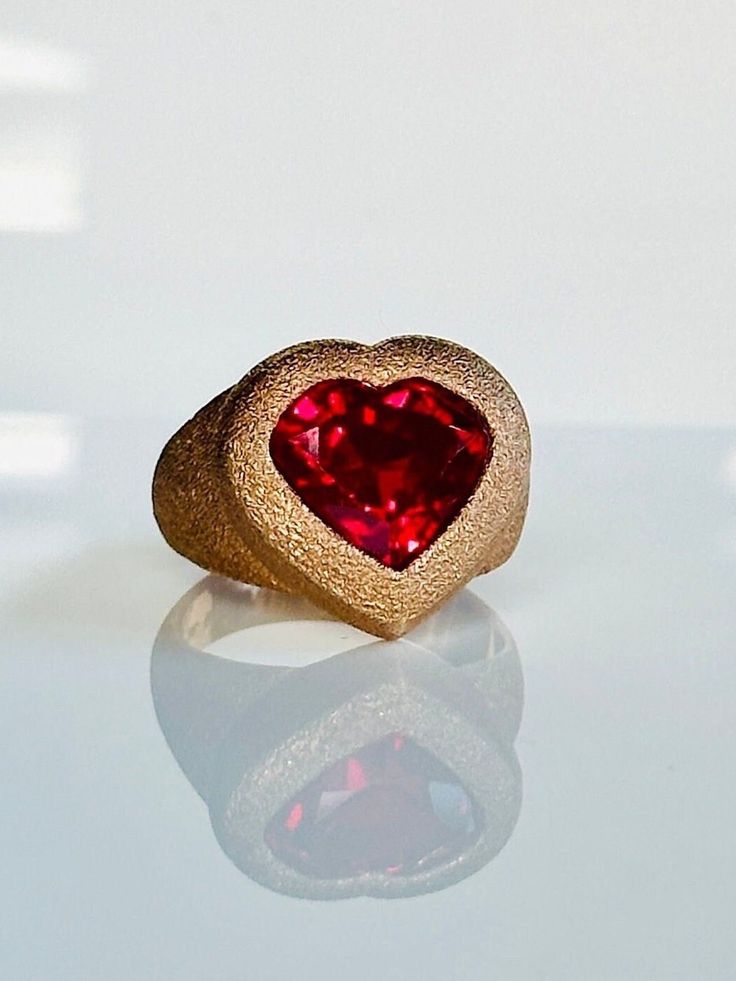 With its sentimental and sweet vibe this ruby signet ring is a modern take on the universal symbol of love. Perfect for everyday or special occasions it adds a fun element to any look. Ring face 17mm x 18mm Ruby 12mm x 11mm Set in 9K hand finished textured rose gold. Can be customized to polished and brushed finish. Weight  9.50-11 grams. Please contact us for sizing options. Follow us on Instagram: https://www.instagram.com/missionewyork/ Valentine's Day Yellow Gold Ruby Promise Ring, Valentine's Day Promise Ruby Ring In Yellow Gold, Yellow Gold Ruby Promise Ring For Valentine's Day, Yellow Gold Ruby Ring For Valentine's Day Promise, Modern Heart Ring For Valentine's Day Gift, Heart-shaped 14k Gold Ruby Promise Ring, 14k Gold Ruby Ring For Valentine's Anniversary, Heart Cut Signet Ring For Anniversary On Valentine's Day, Valentine's Day 14k Gold Red Ruby Ring