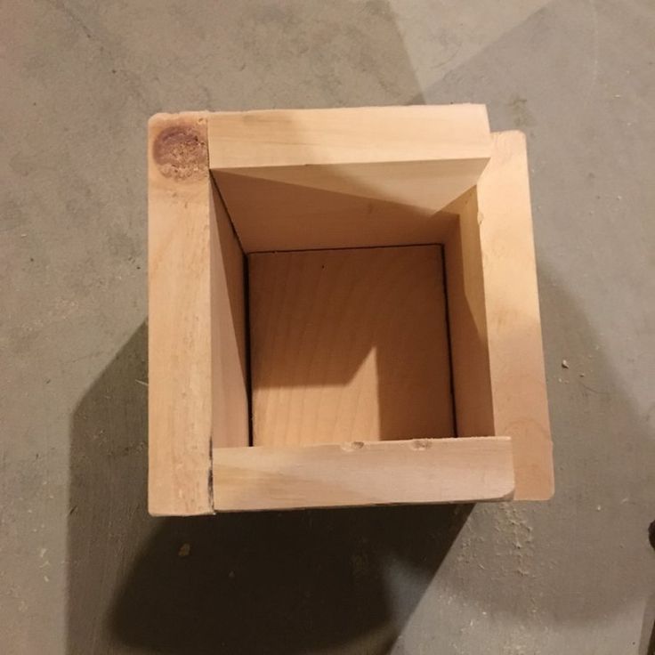 a wooden box sitting on top of a cement floor