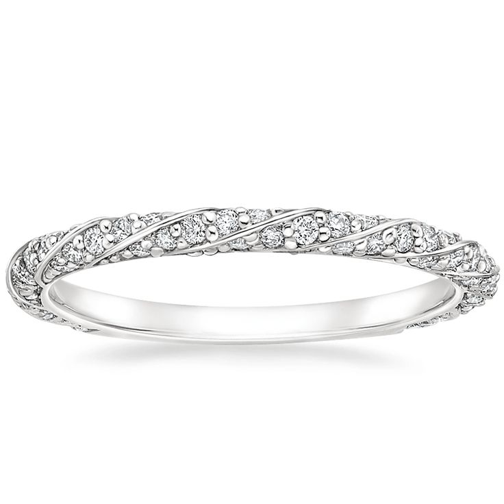 a white gold wedding ring with diamonds on the sides and an intricate design in the middle