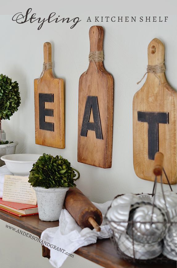 a kitchen shelf with cutting boards on it