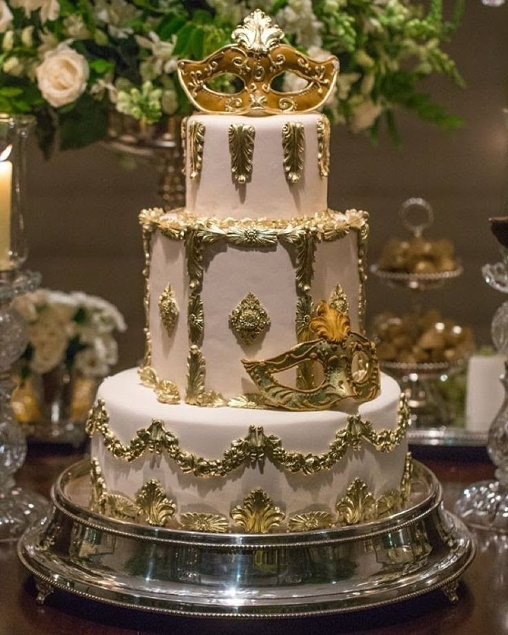 a white and gold wedding cake on a table