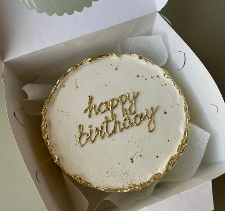 a birthday cake with the words happy birthday written on it in gold foil and white frosting