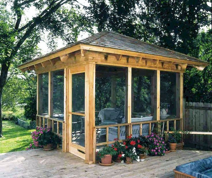 a gazebo sitting on top of a wooden deck next to a hot tub covered in flowers