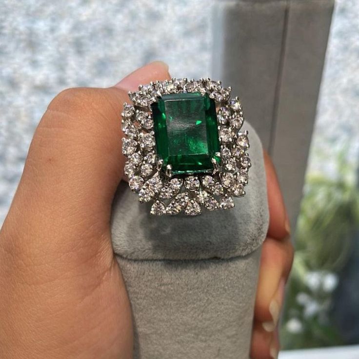 "𝐃𝐞𝐬𝐜𝐫𝐢𝐩𝐭𝐢𝐨𝐧 : *Cocktail Ring For Women, Green Emerald Cut CZ Stone Ring, 925 Silver Party Wear Ring, Wedding Bridal Ring, Engagement Anniversary Gift Ring. ❖ 𝐃𝐢𝐚𝐦𝐨𝐧𝐝 𝐃𝐞𝐭𝐚𝐢𝐥𝐬 *Color : White, Green *Clarity : VVS *Cut : Excellent *Center Stone Shape : Emerald Cut *Center Stone Size : 11*9 MM *Center Stone Weight : 5.21 CT *Side Stone Size : 1.60, 1.70, 2.00 MM *Side Stone Weight : 1.30 CT  *Total Carat Weight : 6.51 CT (Approx.) *Type : Cubic Zirconia (CZ) *We have all types of fancy & color Gemstone. For more queries please contact us immediately. ❖ 𝐑𝐢𝐧𝐠 𝐃𝐞𝐭𝐚𝐢𝐥𝐬 *Metal Purity : Solid Gold (10K, 14K, 18K); 925 Sterling Silver *Stamp : Yes (As per metal purity) *SKU : SR16379 *Making Process : Handmade > Crafted by our experienced craftsman. ❖ 𝐂𝐮𝐬𝐭𝐨𝐦 Luxury Unique Green Diamond Ring, Luxury Silver Cluster Ring With Emerald, Luxury Green Topaz Ring For Anniversary, Exquisite Gemstone Party Rings, White Gold Gemstone Rings For Party, Emerald Cluster Ring With Diamond Accents For Wedding, Party White Gold Gemstone Rings, Party Rings In White Gold With Gemstone, Elegant Diamond Ring For Party