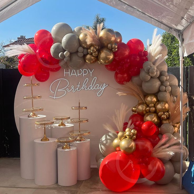 a birthday party with balloons, candles and decorations on the side of a tented area