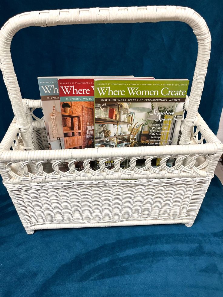 a wicker basket with magazines in it on a blue blanketed surface, ready to be used as a magazine holder