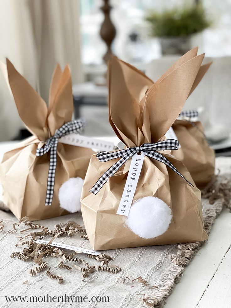 two brown paper bags with white pom - poms tied to them on a table