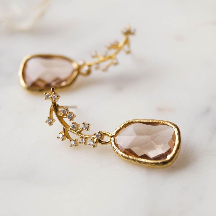 Our Juniper Branch Earrings are perfectly boho chic. They're simple, dainty and won't overpower your entire look on your special day! These also make a perfect gift for bridesmaids for a classic bohemian look.FEATURES Champagne hued glass drops set in 16k gold plating White cubic zirconia encrusted leaf post (925 sterling post) 100% nickel free, can be worn by people with sensitive ears Juniper Branch, Champagne Earrings, Branch Earrings, Gift For Bridesmaids, Dainty Gold Necklace, Chain Extenders, Bohemian Earrings, Earrings Boho, Dainty Earrings