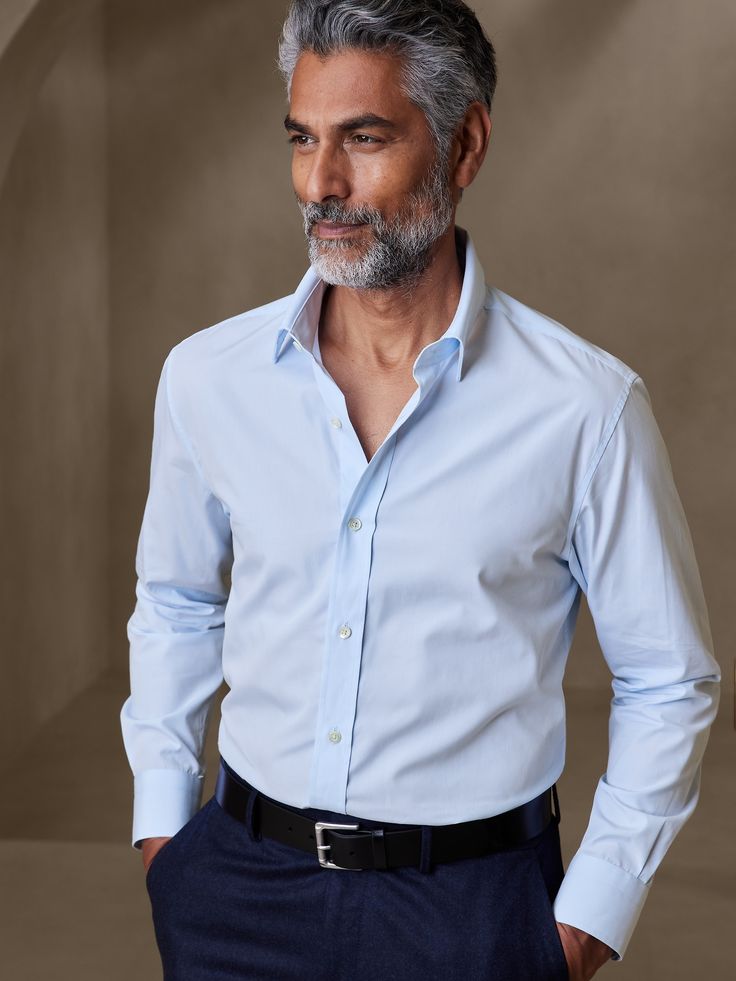 Made from 100% cotton, our luxurious 120s poplin fabric is woven from 2-ply yarns which give it added opacity and a smooth, soft feel against the skin.  Tailored Slim Fit: More at-ease than our Slim fit.  Expertly tailored with room through the arms and back for a perfect fit.  Spread collar.  Button placket.  Shirttail hem.  Tailored Slim Fit: More at-ease than our Slim fit.  Expertly tailored with room through the arms and back for a perfect fit.  Long sleeves.  Hip length.  Model: Size M, 6'2 Business Clothes Men, Men’s Button Up Style, Blue Button Up Shirt Outfit Men, Clothes Wrinkles, Blue Pants Men, Men Dress Shirt, Baby Blue Shirt, Dress Shirt Men, Dark Blue Shirt