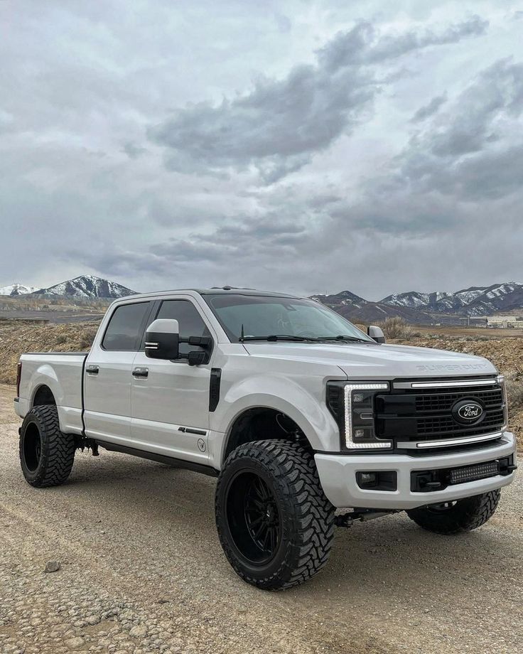 a white truck parked on top of a dirt road