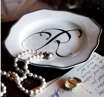 a white and black plate with pearls on it sitting next to a note that says p