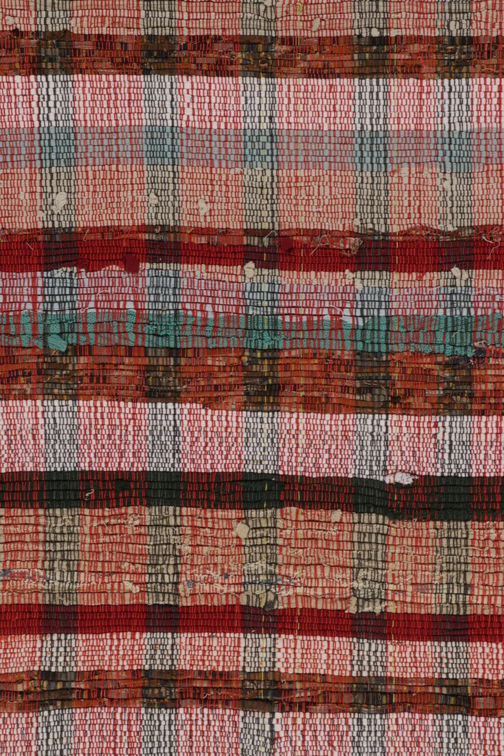 an orange and red plaid fabric textured with small squares, stripes, and dots