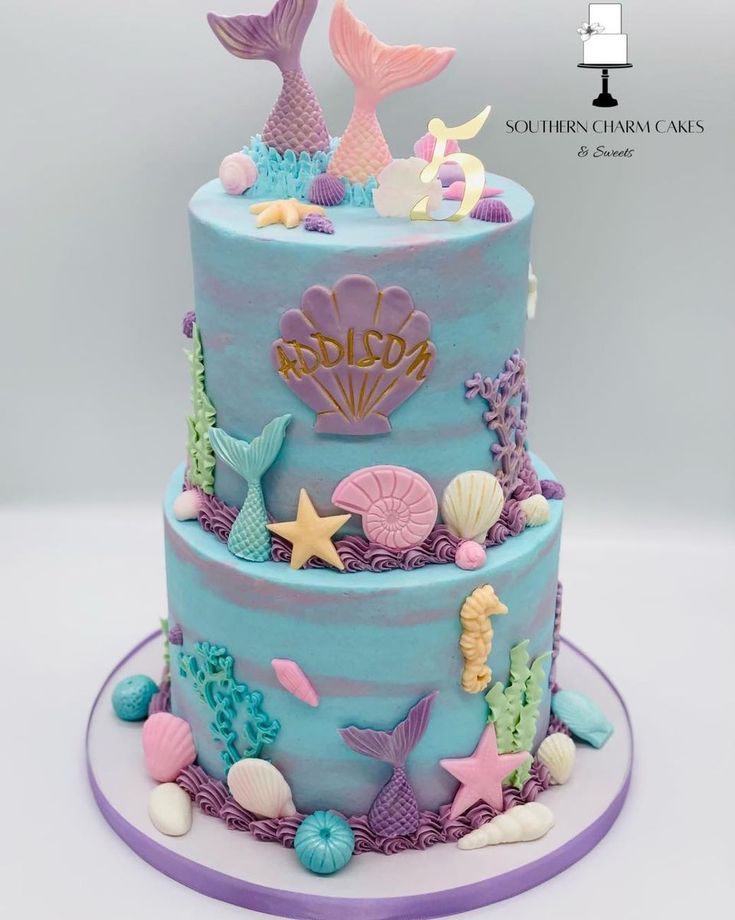 a three tiered cake decorated with sea animals and seashells